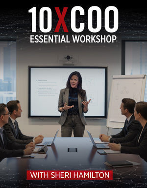 Sheri Hamilton leading an executive-level training session, standing at the front of a conference room while speaking to a group of business professionals seated around a table during the 10X COO Essential Workshop.